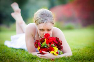 A woman sniffing her bouquet of flowers