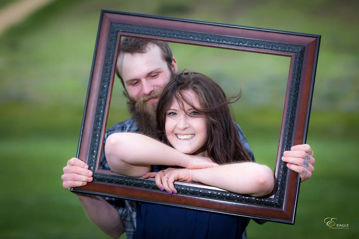 A man holding a frame with his girlfriend